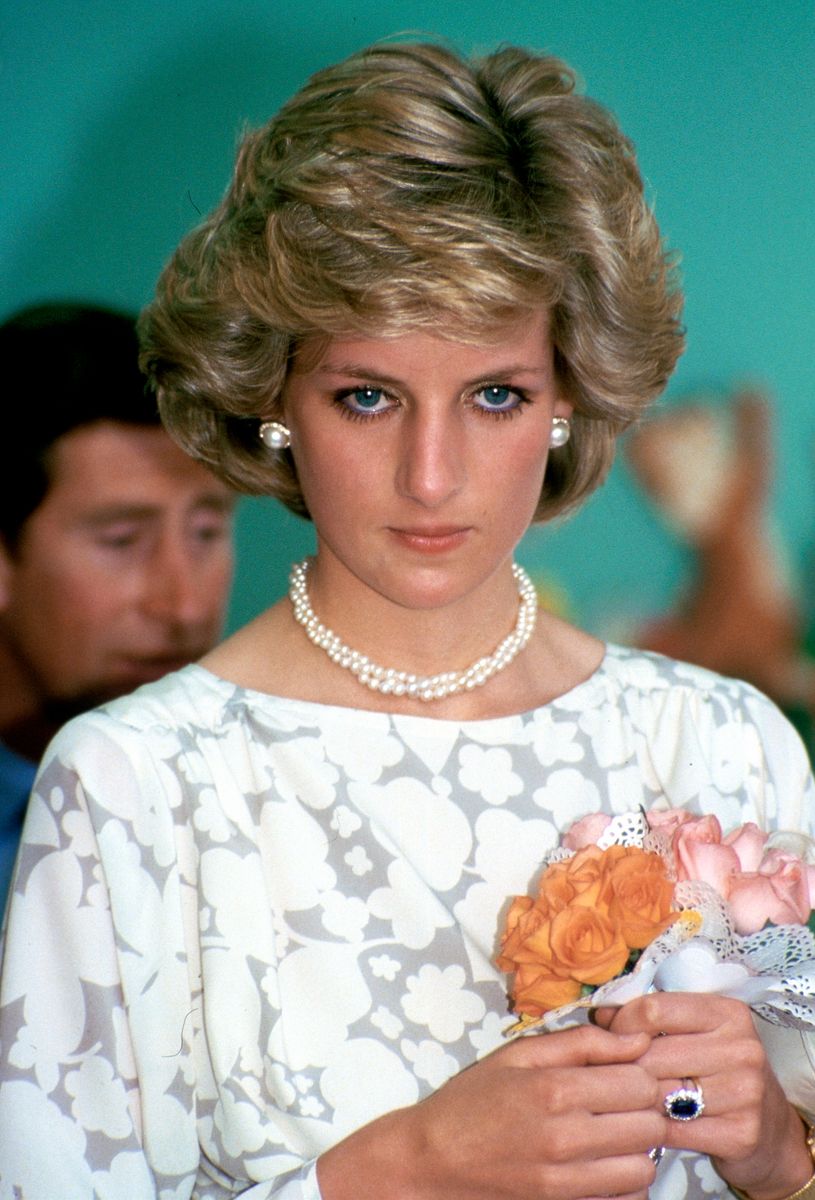Diana, Princess Of Wales Looking Sad During An Official Overseas Visit. She Is Wearing Pearl Necklace And Earrings And Holding A Bouquet Of Roses