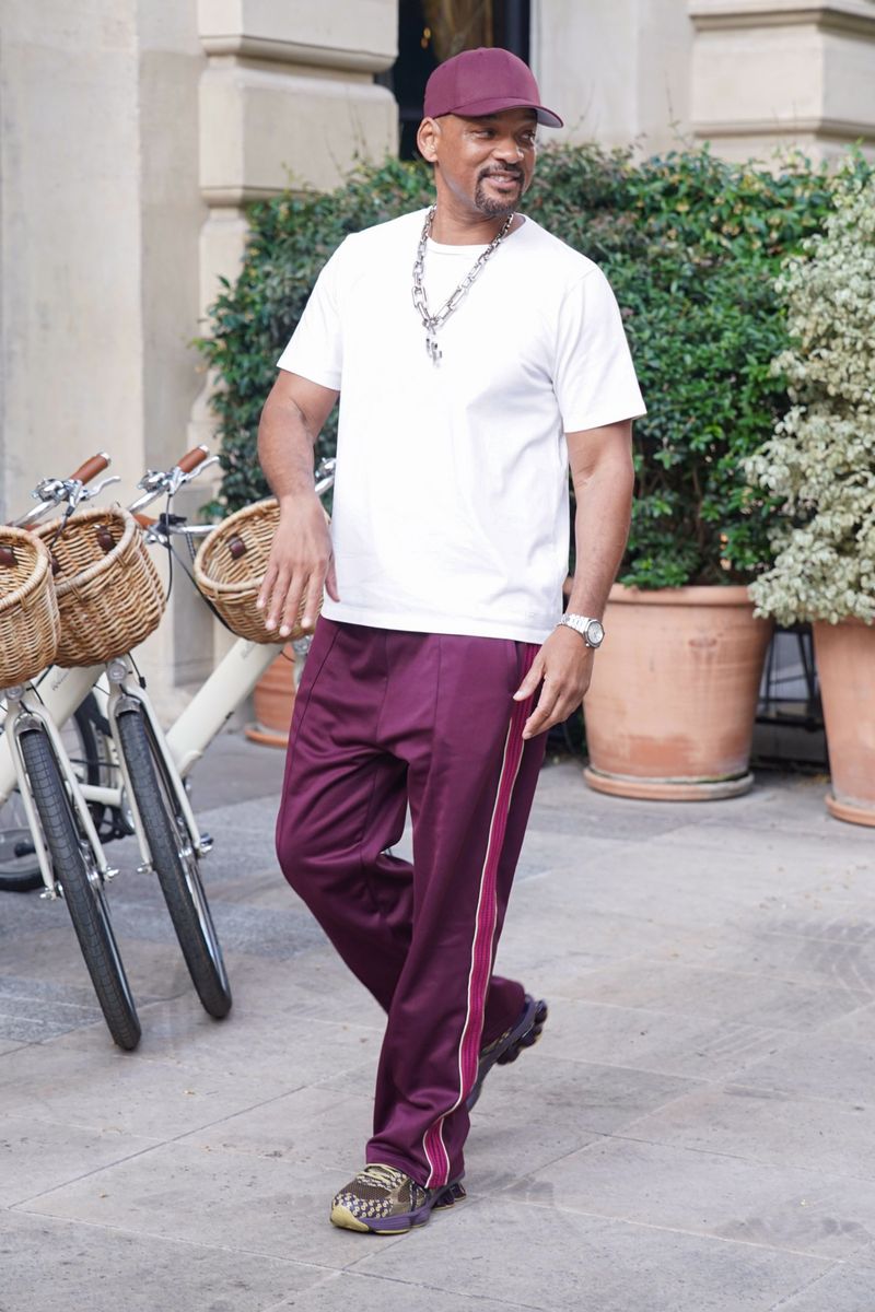 Will Smith kept his look relaxed in an oversized white T-shirt, burgundy track pants, a matching cap, and chunky sneakers.