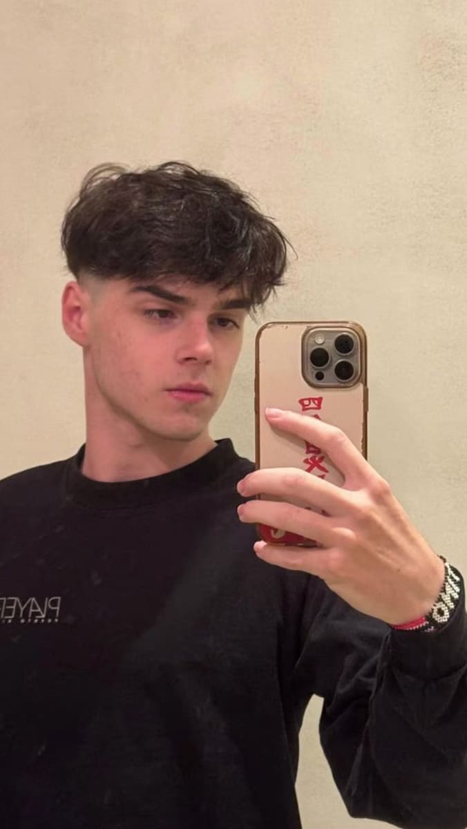His photo shows him with a textured French crop cut