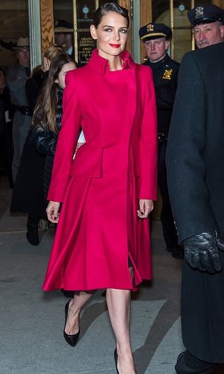 Katie Holmes turns heads outside the Zac Posen fashion show in a bright red classic coat.