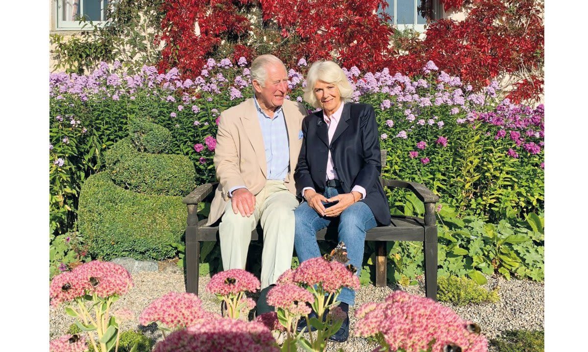 Charles and Camilla posed for their holiday photo on a bench in the garden at Birkhall