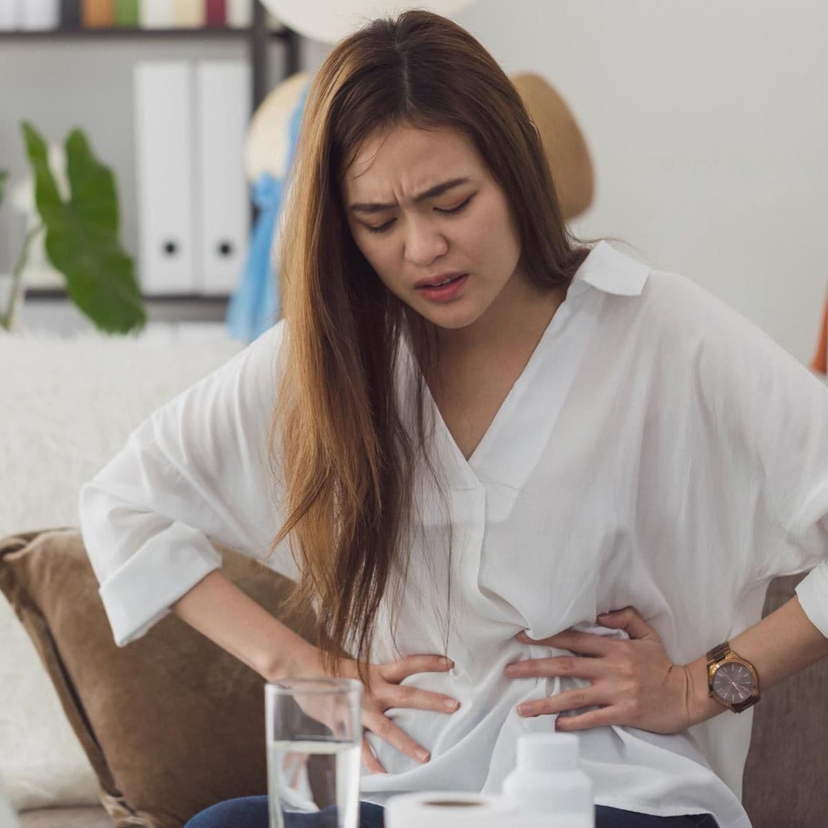 Portrait Of Young Woman Touching Stomach In Pain