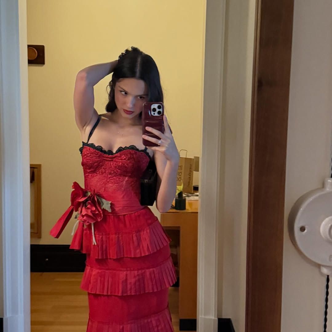 Olivia Rodrigo posed in a tiered red lace dress, complete with a black lace neckline