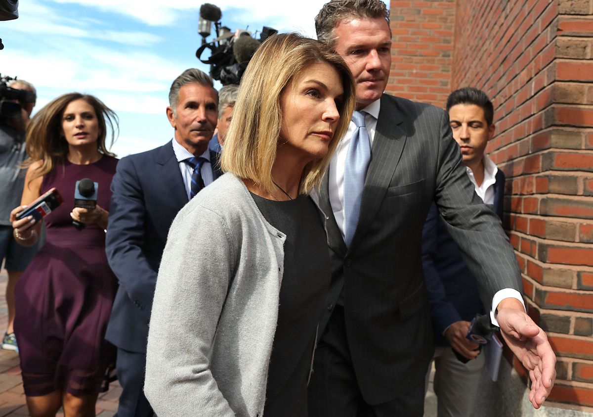Lori Loughlin and her husband Mossimo Giannulli, behind her at left, leave the John Joseph Moakley United States Courthouse in Boston on Aug. 27, 2019.