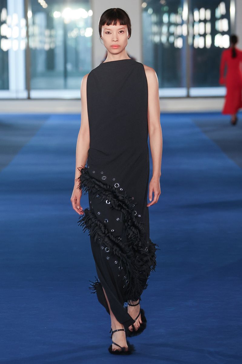 The original Proenza Schouler Fall 2026 runway look featured the same sculptural silhouette, textured fringe, and silver eyelet detailing that Michelle Obama later showcased on stage.