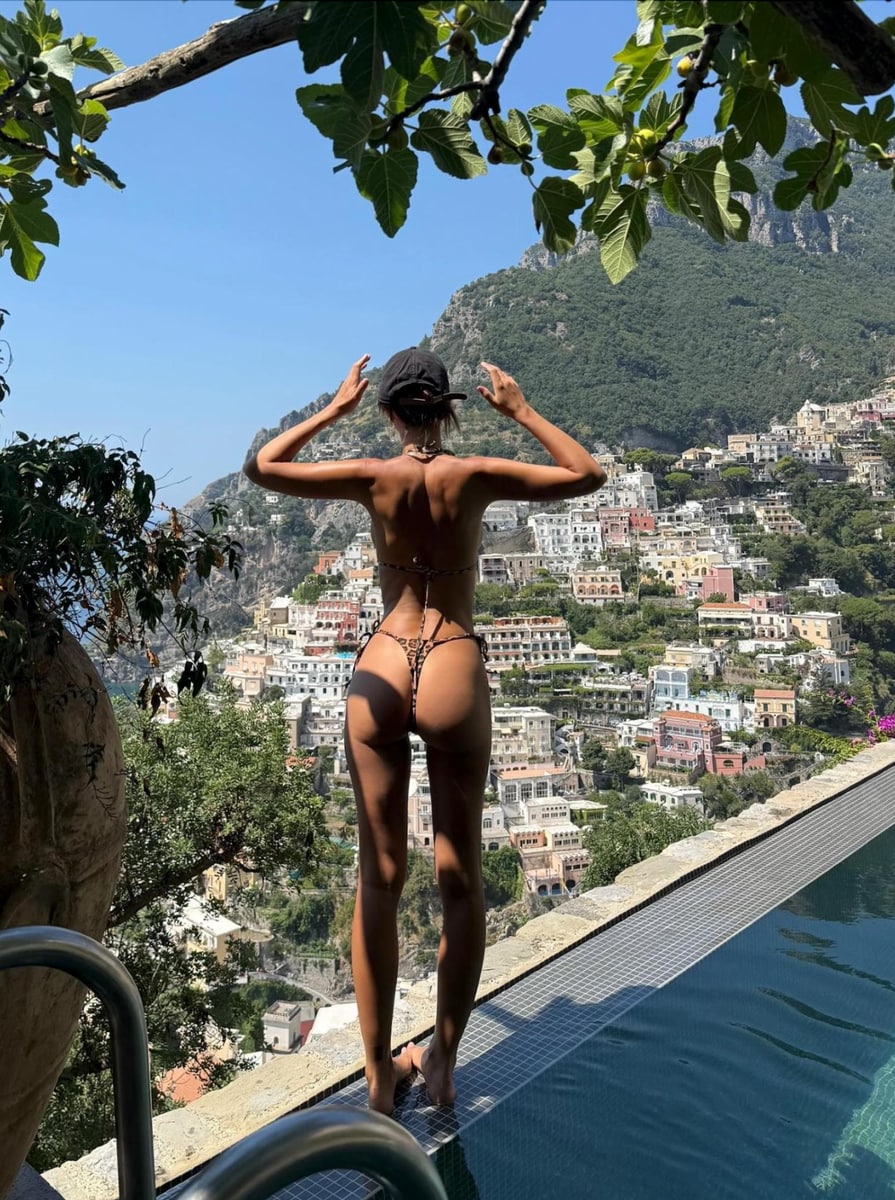 Ratajkowski faced away from the camera in a stunning leopard-print thong bikini, overlooking Positano’s signature colorful buildings. 