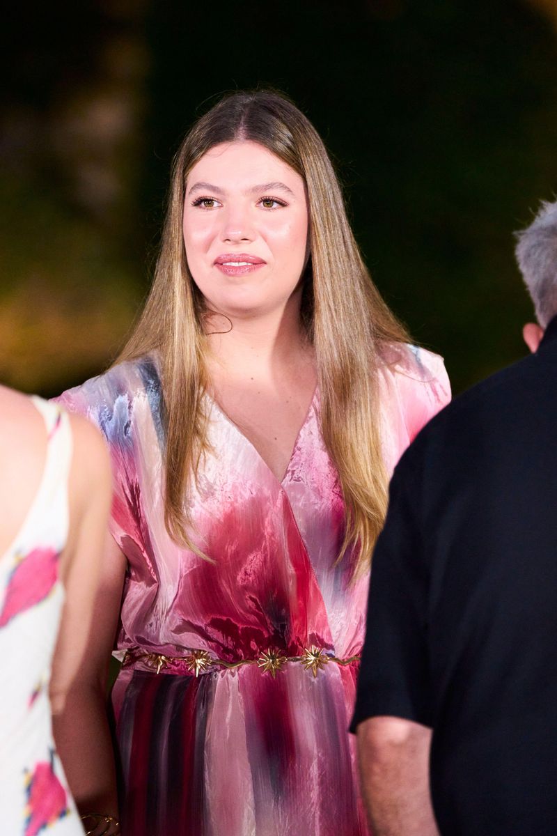 Infanta Sofía wore her long highlighted hair sleek and straight with a center part, complementing her romantic pink watercolor-print maxi dress with a delicate gold belt.