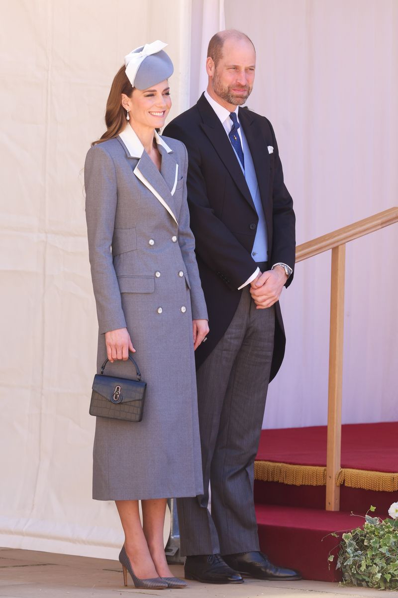 She wore a striking long, two-tone coat in grey and white, reminiscent of 1980s tailoring, featuring a double-breasted silhouette and corset-style detailing at the back.