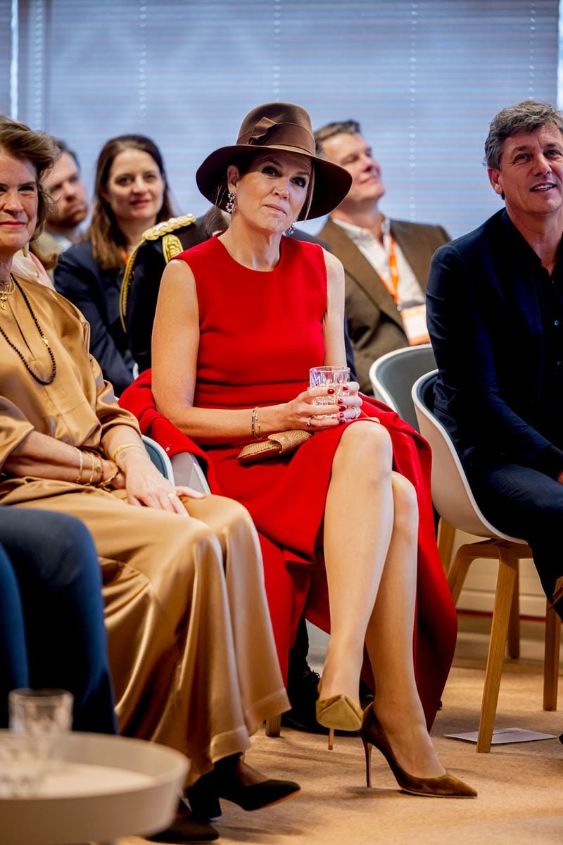 For this event, the Queen rewore a sleeveless, midi-length red dress, pairing it with her Davia cape by Natan.