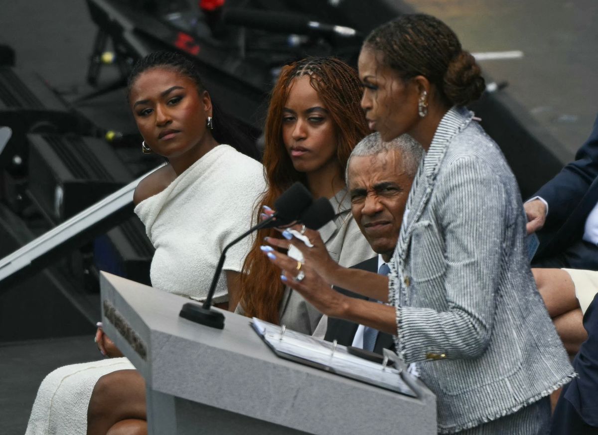 (L/R) Sasha Obama, Malia Obama and former US president Barack Obama listen to former US first lady Michelle Obama speak at the opening of the Barack Obama Presidential Center