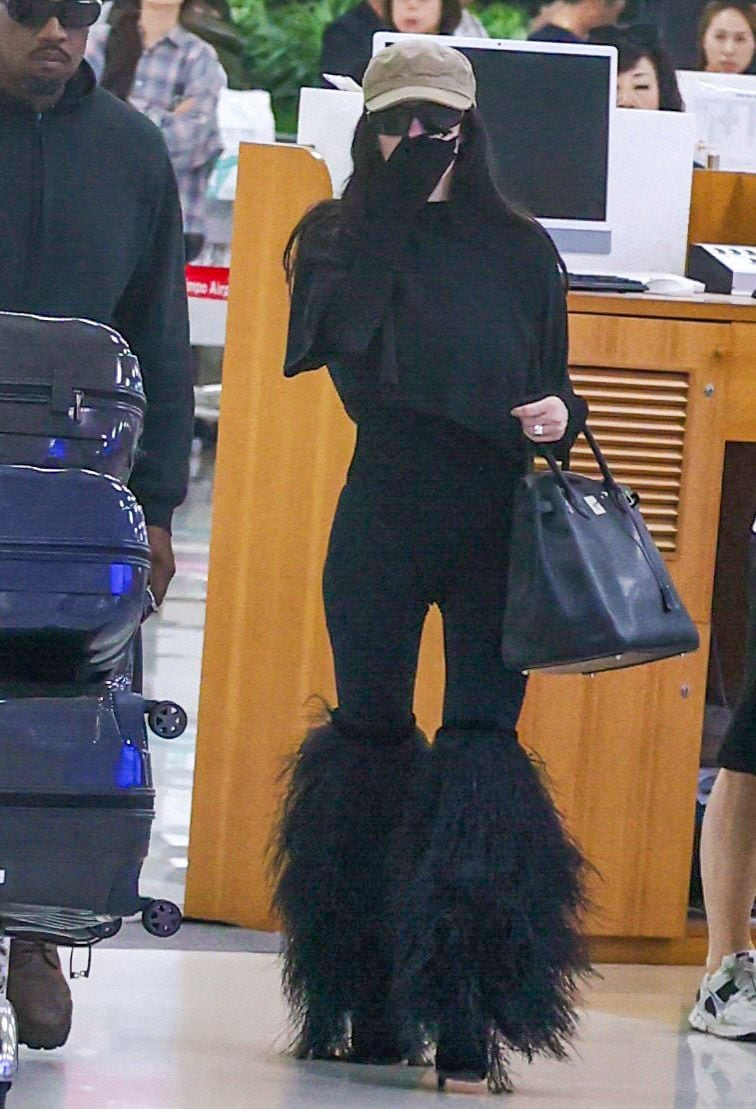 Bianca llevaba botas altas de rodilla emplumadas y llevaba una gran bolsa Birkin Hermes. 