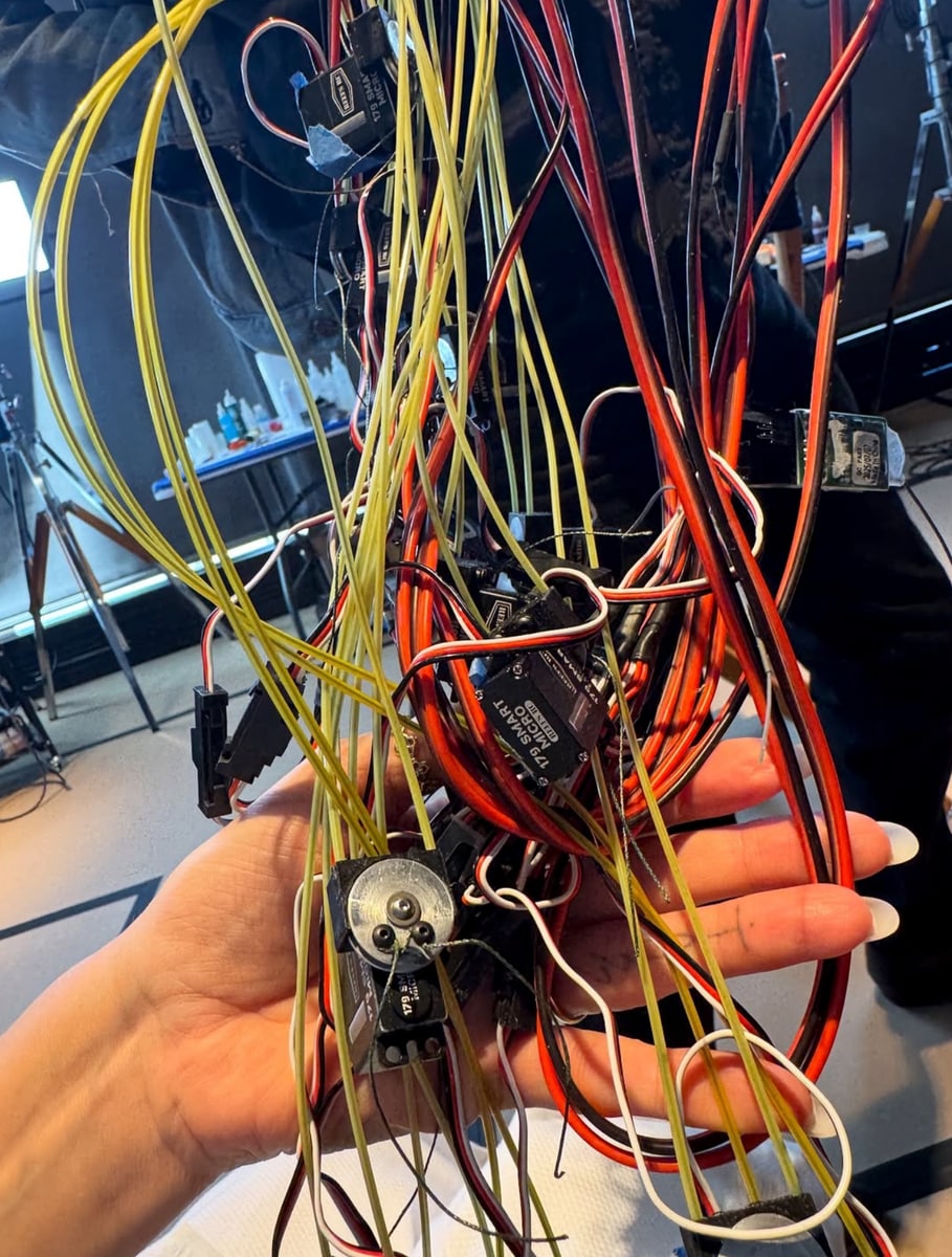 Behind-the-scenes images show Klum with green prosthetics and holding wires for animatronics, hinting that her costume could combine makeup, practical effects, and robotics.