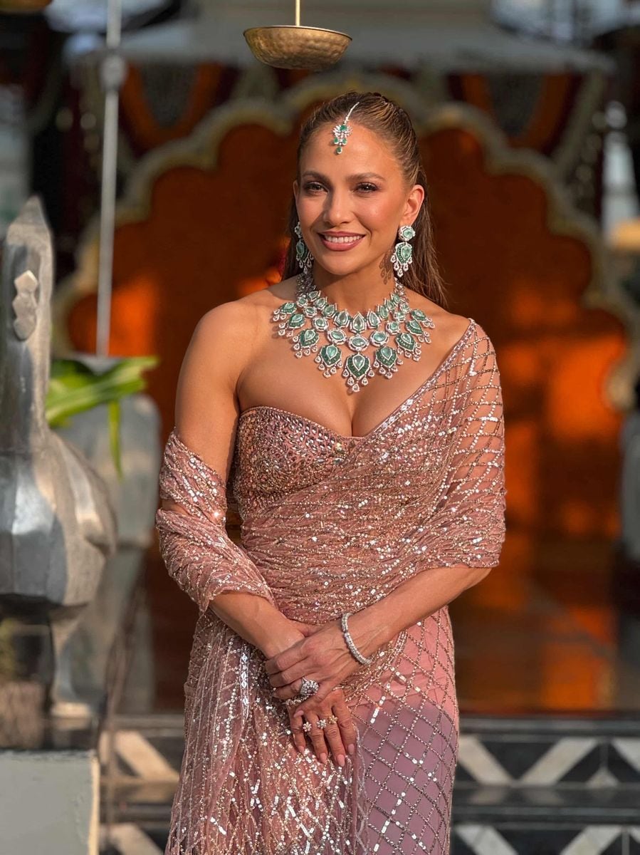 
Jennifer Lopez is wearing a blush-toned, sequined sari-style gown with a structured bodice.