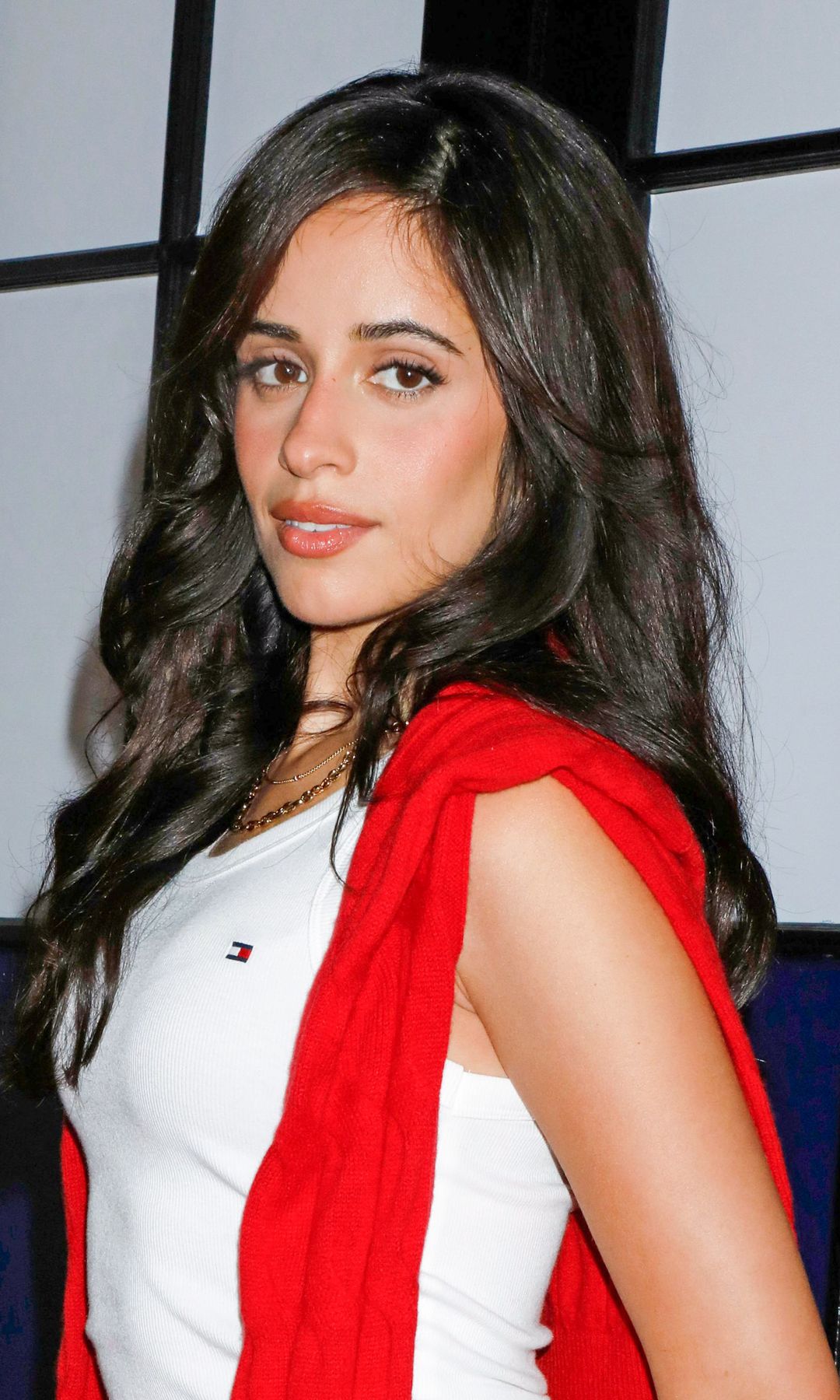 Camila Cabello puts a flirty twist on preppy style in a red knit mini skirt and sky-high white boots