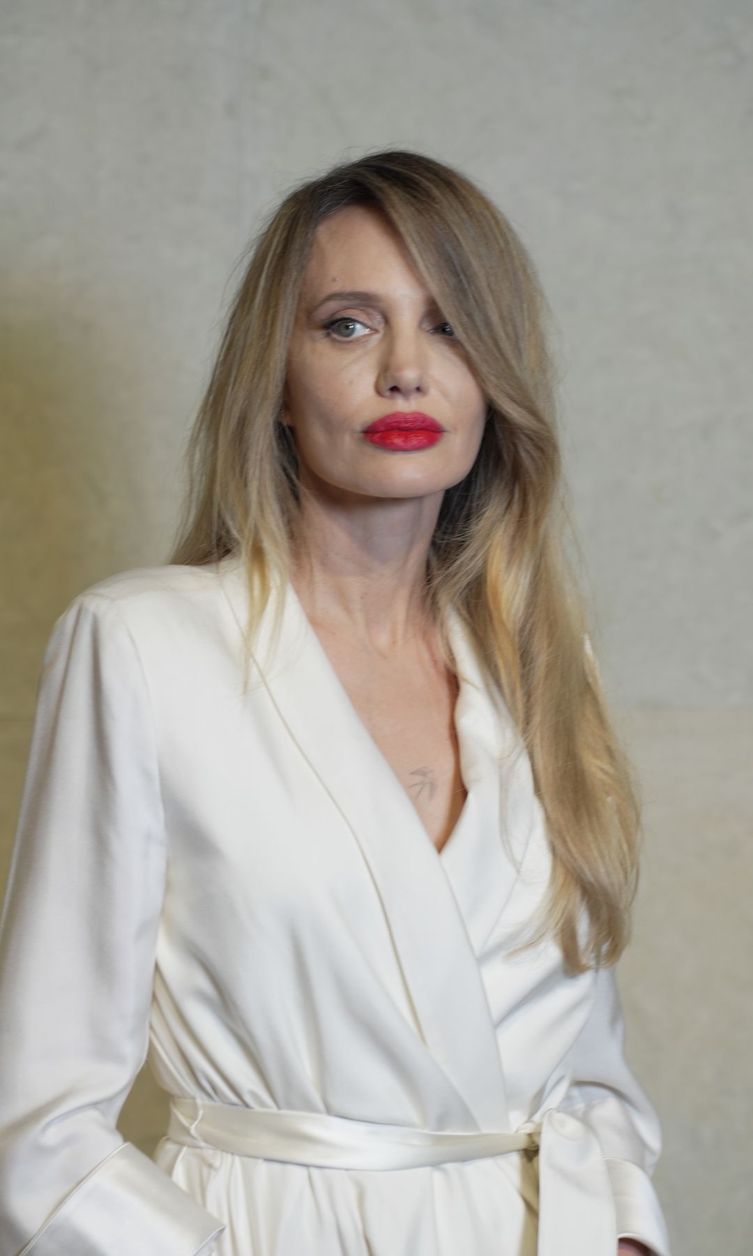 Angelina Jolie stuns in sleek white wrap dress and bold red lip at surprise  Shanghai appearance