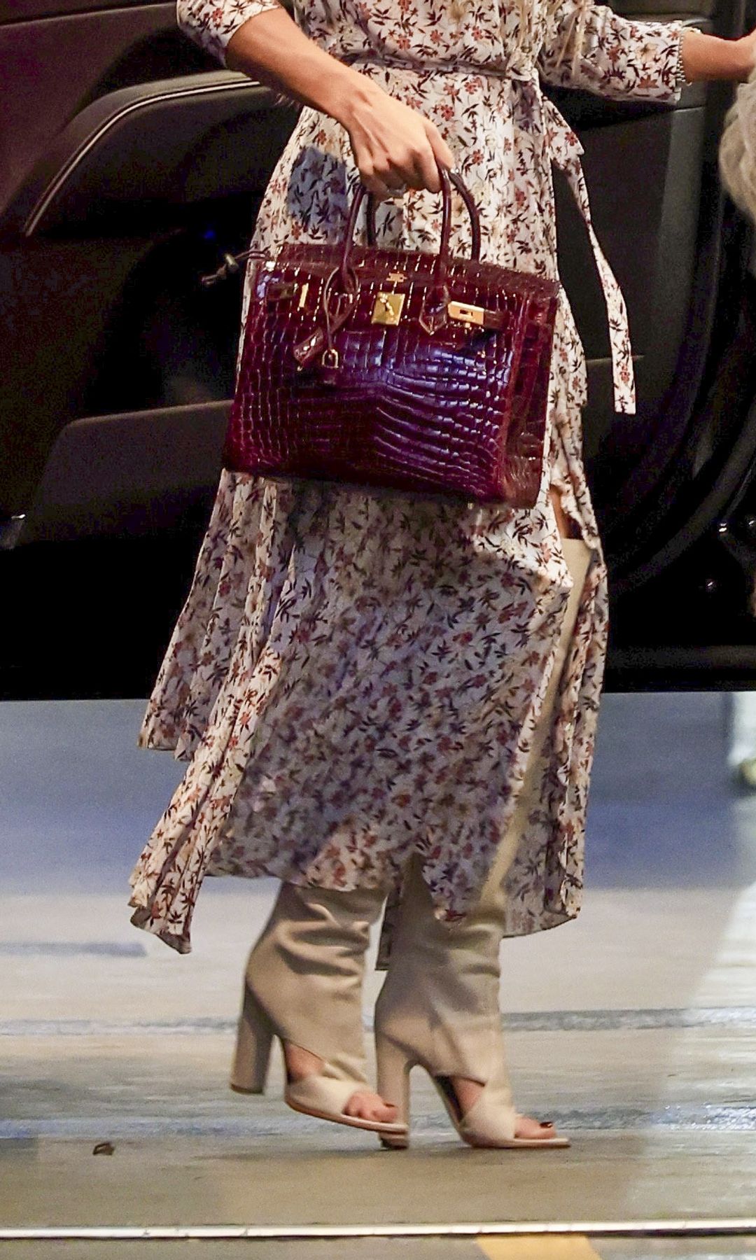

Jennifer Lopez looked gorgeous arriving at the office wearing a floral long dress, long open-toe boots, a fur vest, and a burgundy Birkin bag.