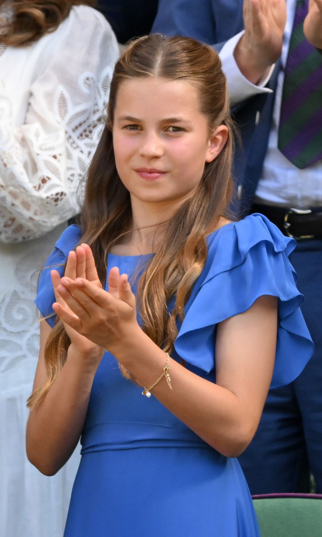 Princess Charlotte charmed spectators in a vibrant blue dress and white ballet flats, a look that echoed one of her mother's past Wimbledon outfits.