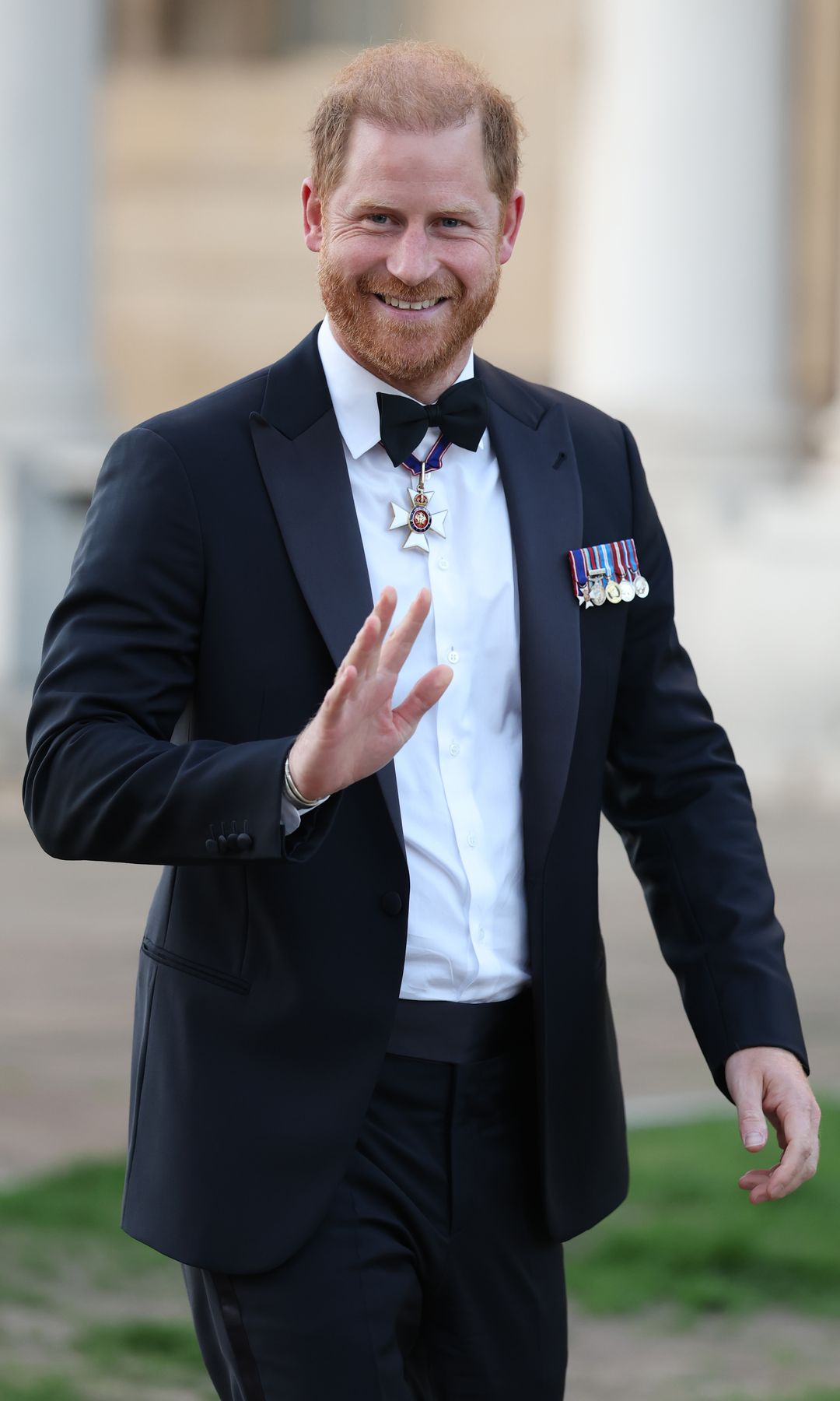 Prince Harry waving to photographers when making his first public appearance since his return to the UK