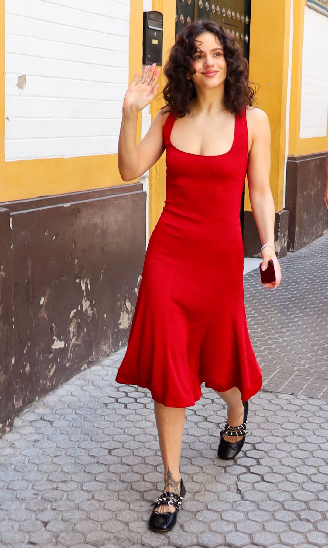 Rosalía wearing a dress red with black Mary Janes