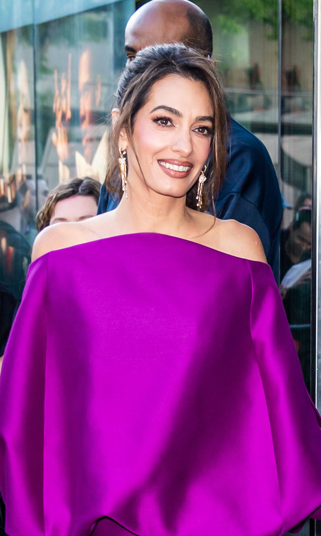 Amal Clooney puts a chic spin on the mini dress, showing off her legs in a bold purple look and gold pumps