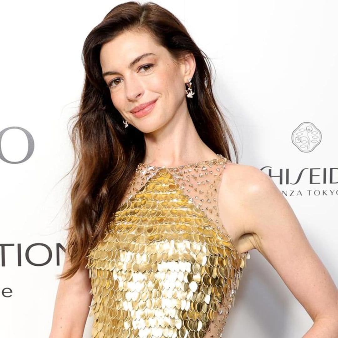Anne Hathaway looks stunning in gold sequin ensemble and diamond earrings