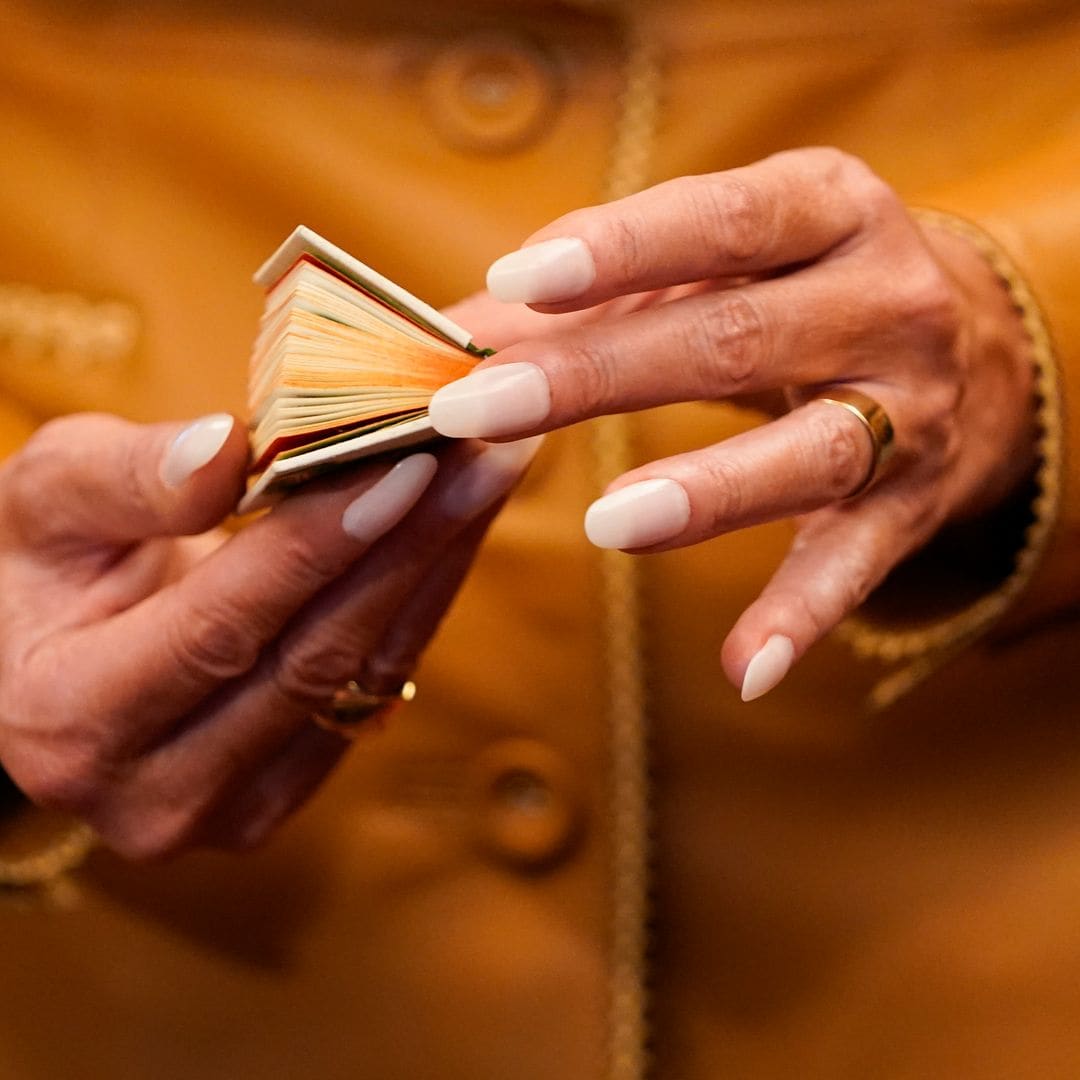  First Lady Melania Trump holds a miniature antique book as she tours the Royal Library with Britain's Queen Camilla 