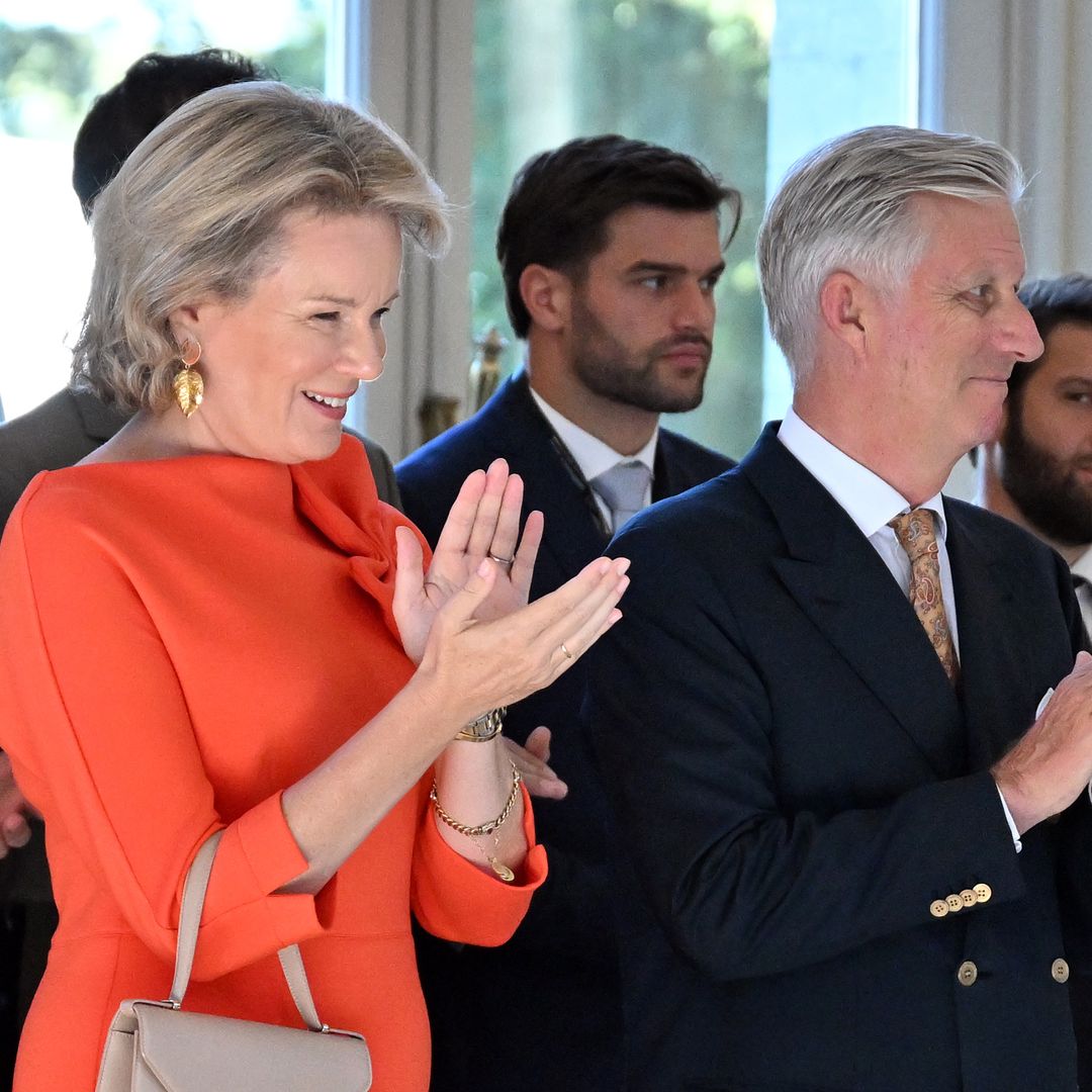 Queen Mathilde brightens up palace reception in an orange dress with a playful twist