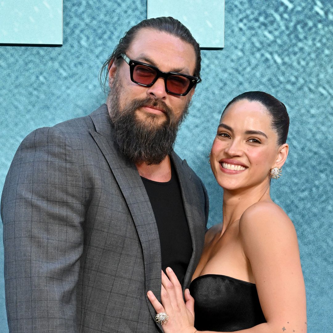 Adria Arjona and Jason Momoa share a sweet kiss on the 'Onslaught' red carpet