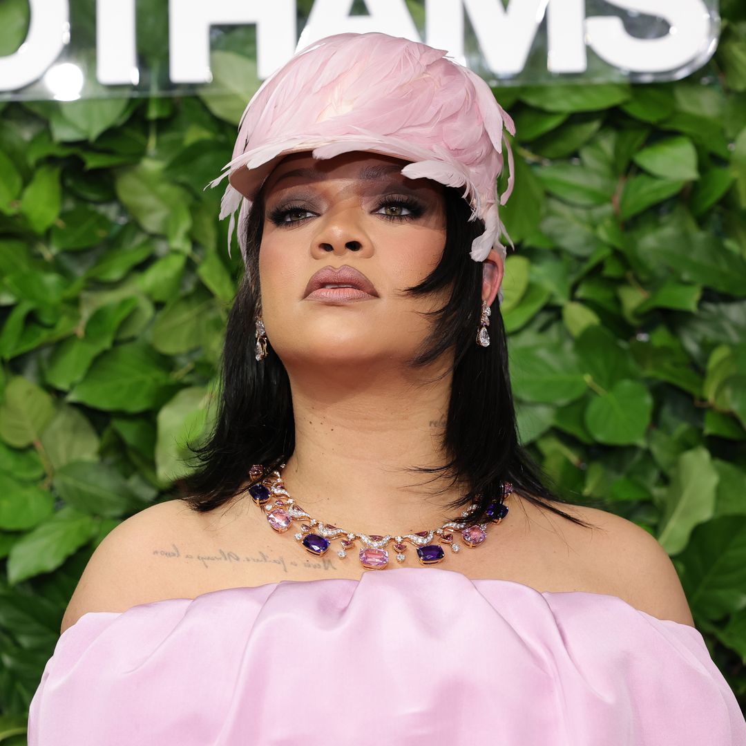 Rihanna wears a dramatic pink gown with a feathered hat at The Gotham Awards