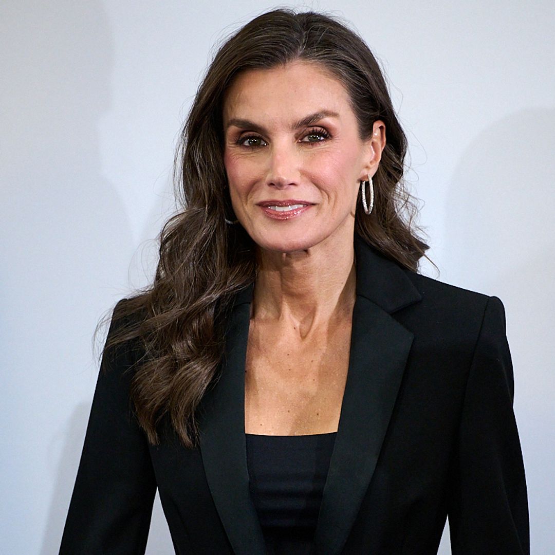 Queen Letizia brings a little drama to her glamorous black suit with a playful finish