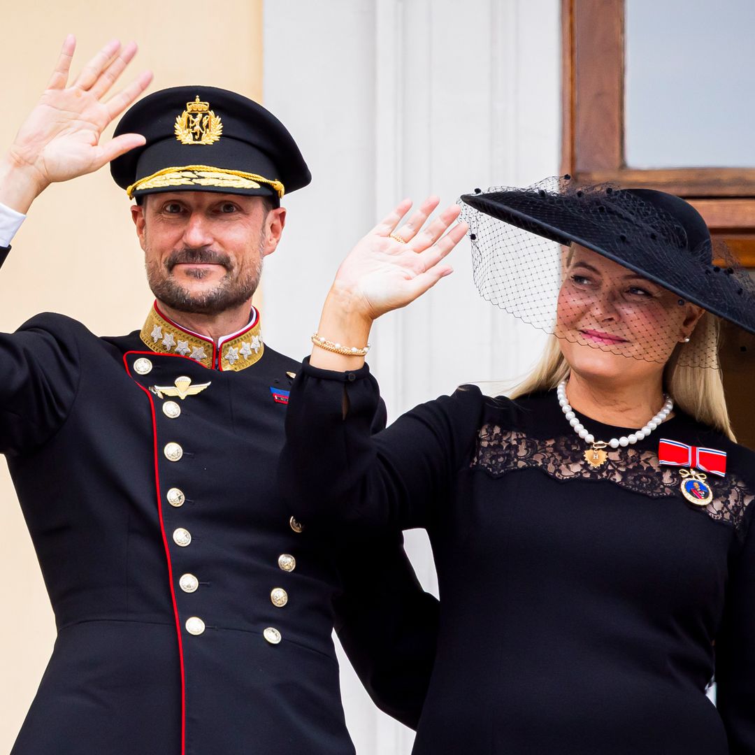King Haakon VIII and Queen Mette-Marit step onto the balcony as a new reign begins