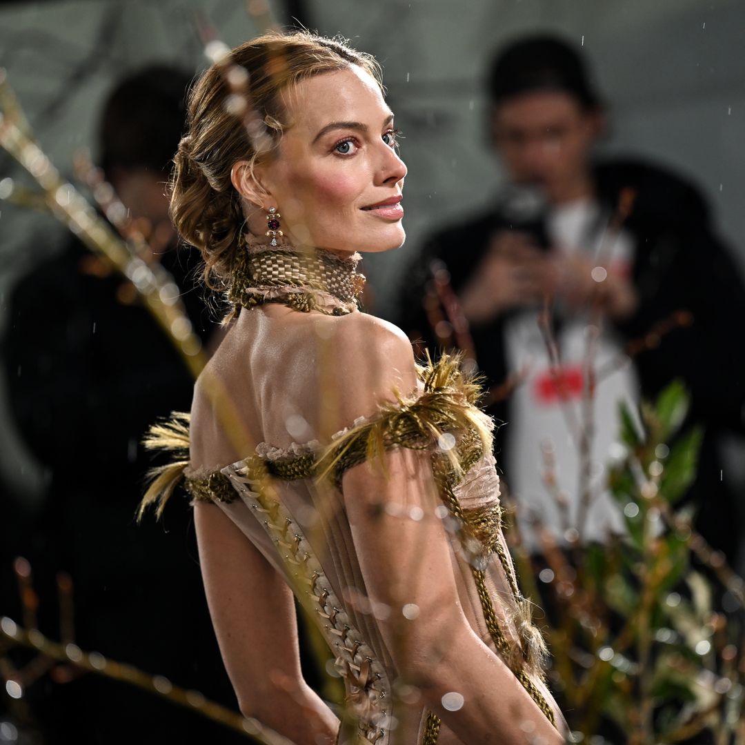 Margot Robbie poses in sheer gown with exposed corsetry and rope-like detailing at 'Wuthering Heights' premiere