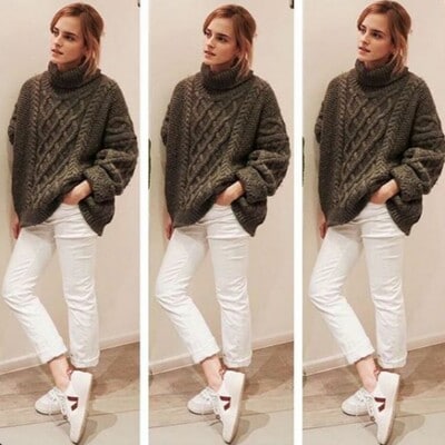 Emma Watson con cabello recogido, suéter de punto, pantalones blancos y sneakers Veja