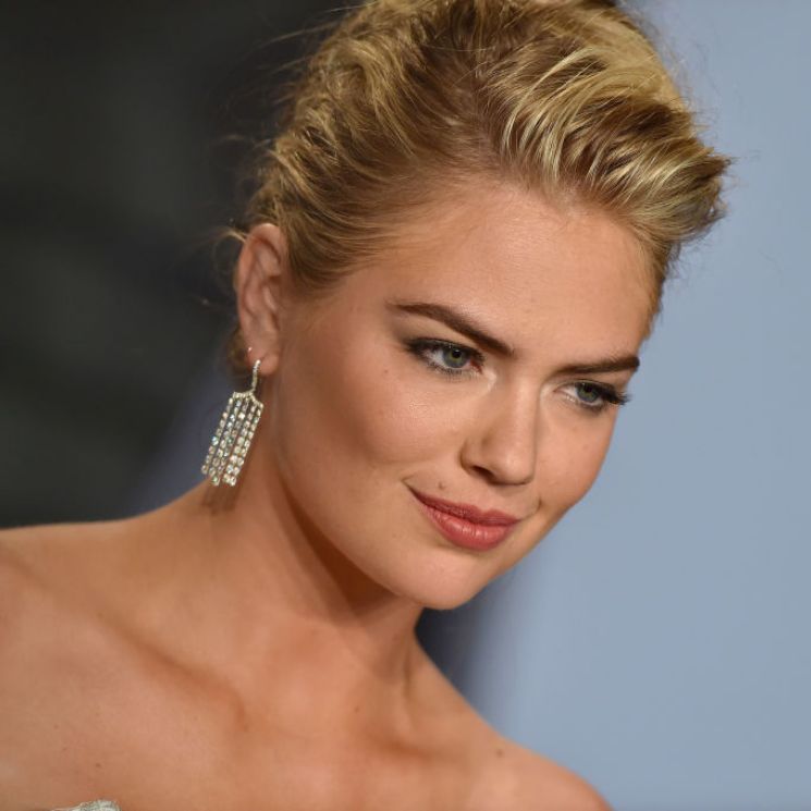 Kate Upton con cabello recogido con un moño y vestido strapless