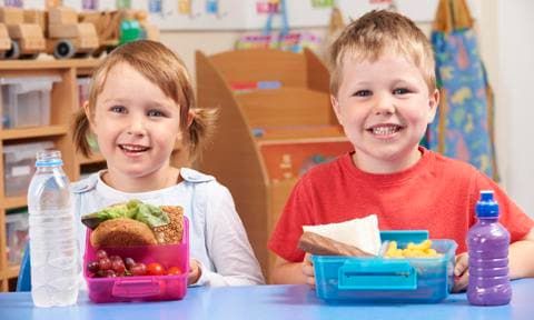Alumnos de escuela primaria con almuerzo saludable
