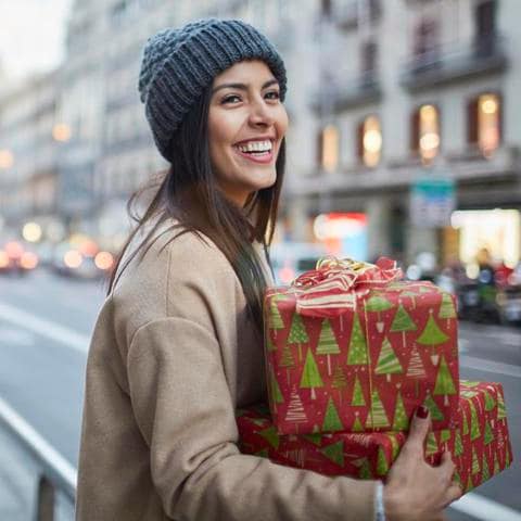 Mujer de compras de regalos de Navidad en la ciudad de acuerdo a las tendencias tecnologicas