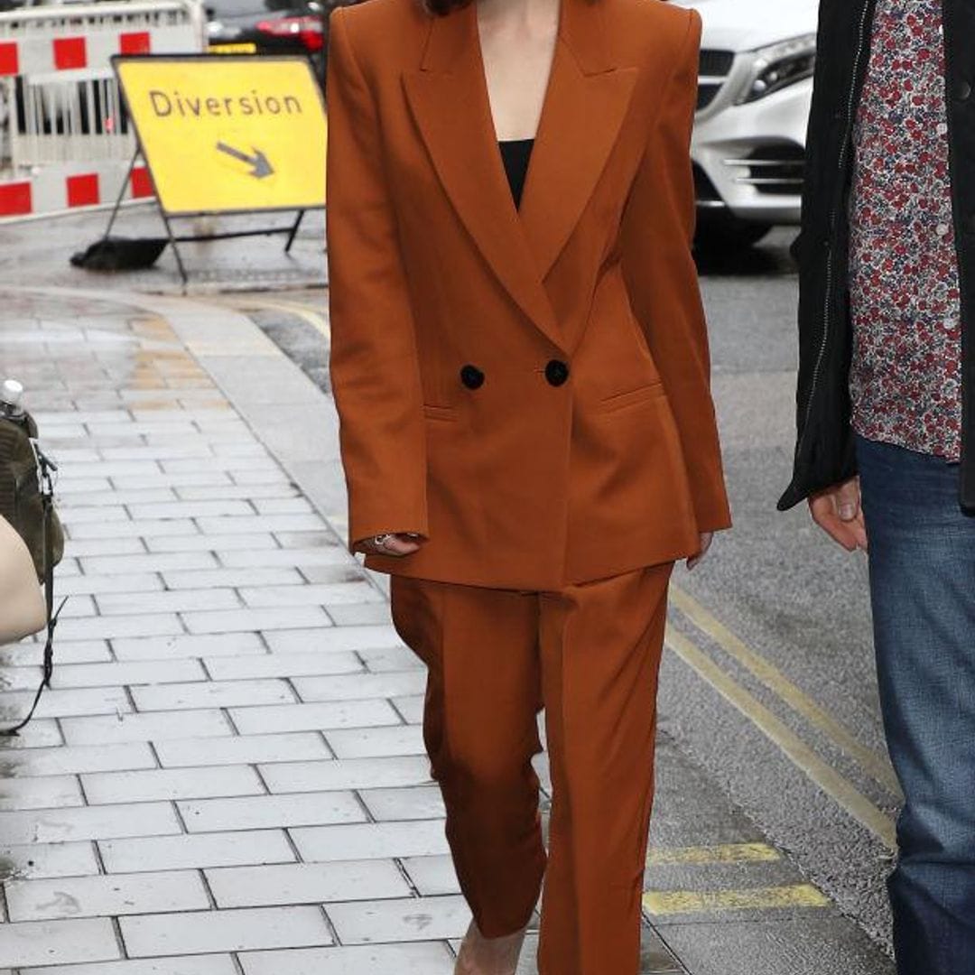 Emilia Clark usando un suit bronce de Petar Petrovn