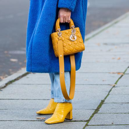 Sonia Lyson con botas de punta cuadrada amarillas y abrigo azul