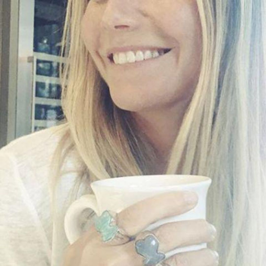 Gwyneth Paltrow con cabello suelto y camiseta blanca tomando en una taza