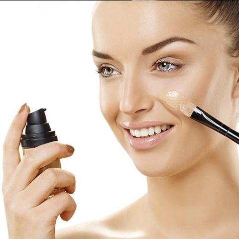 Mujer aplicando un tinted moisturized con un pincel en su rostro