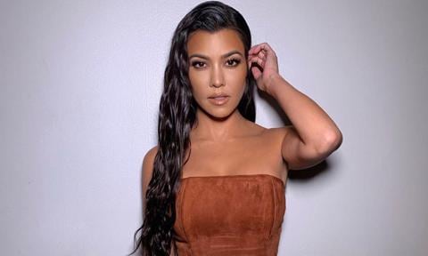 Kourtney Kardashian con vestido de ante marrón