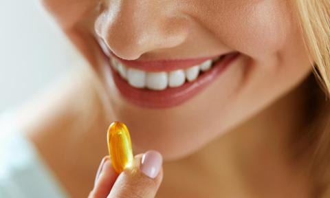 mujer toma vitaminas para el beneficio de las uñas