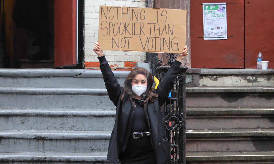 Vanessa Hudgens pictured keeping social distance and protective mask and a sign to promote the upcoming election.