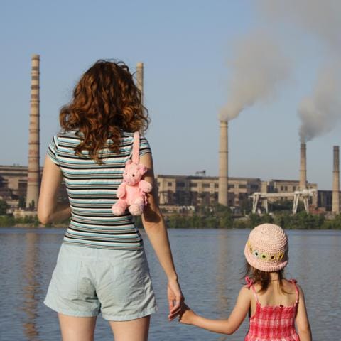 Madre e hija observando contaminación industrial