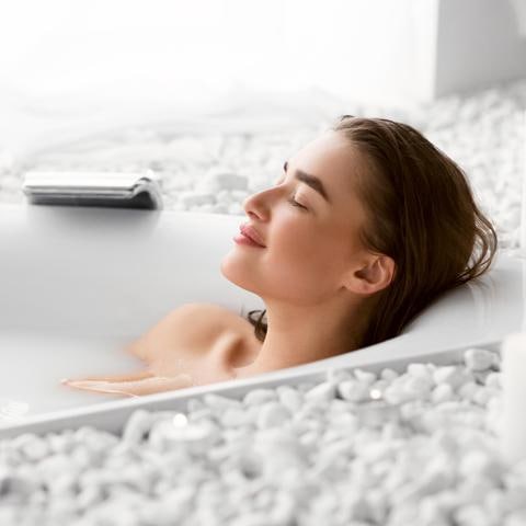 Mujer tomando un baño caliente relajada y feliz