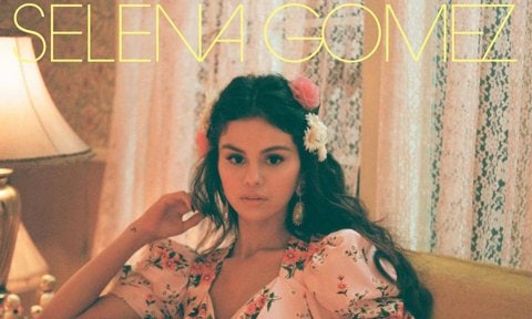 Selena Gomez De Una Vez Cover Art. Sitting on couch in pink floral dress with illuminated heart.