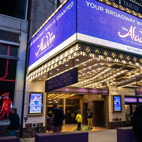 People walk past the New Amsterdam Theatre home to “Aladdin” which has postponed shows due to COVID-19 outbreaks on December 21, 2021 in New York City.