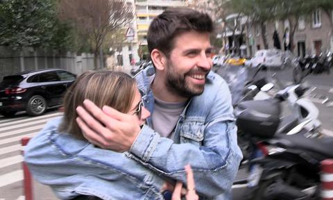 Gerard Piqué and Clara Chia laugh out loud after she hits herself with an advertising sign trying to hide from a paparazzi